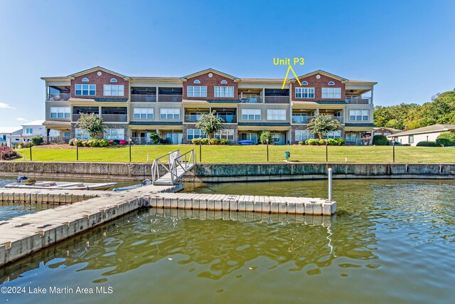 view of dock with a yard and a water view