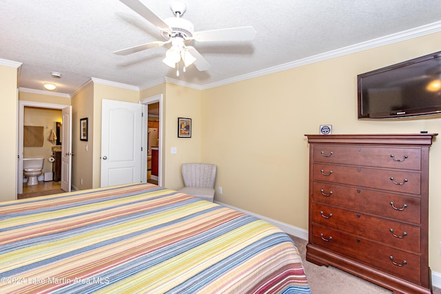 carpeted bedroom with a textured ceiling, ceiling fan, crown molding, and ensuite bath