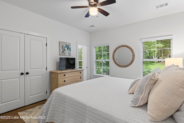 280 Whisper, Tallassee, AL 36078 - bedroom featuring dark wood-type flooring, multiple windows, a closet, and a ceiling fan