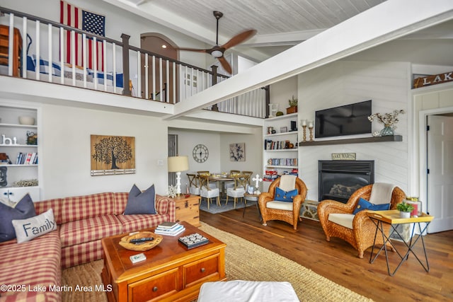 421 Mccain Rd, Eclectic, AL 36024 - living room with wood finished floors, a glass covered fireplace, ceiling fan, built in features, and wooden ceiling with exposed beams