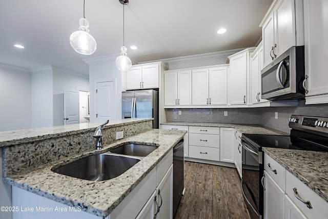 kitchen featuring sink, stainless steel appliances, an island with sink, white cabinets, and decorative light fixtures