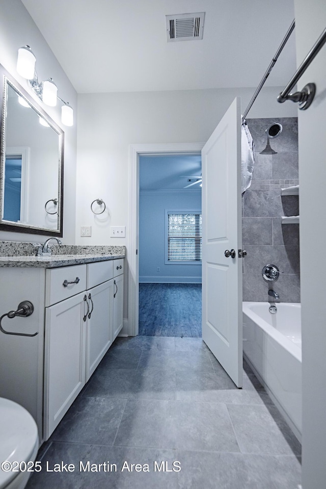 bathroom featuring tiled shower / bath and vanity