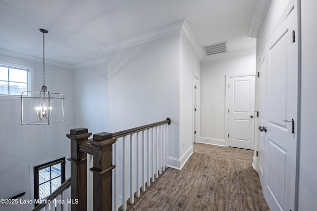 hall featuring crown molding, dark wood-type flooring, and a chandelier