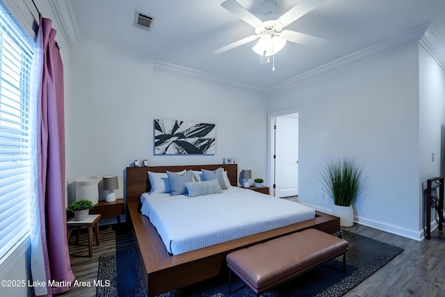 bedroom with hardwood / wood-style floors, ornamental molding, and ceiling fan