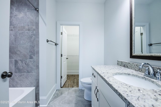 full bathroom featuring vanity, tiled shower / bath, and toilet