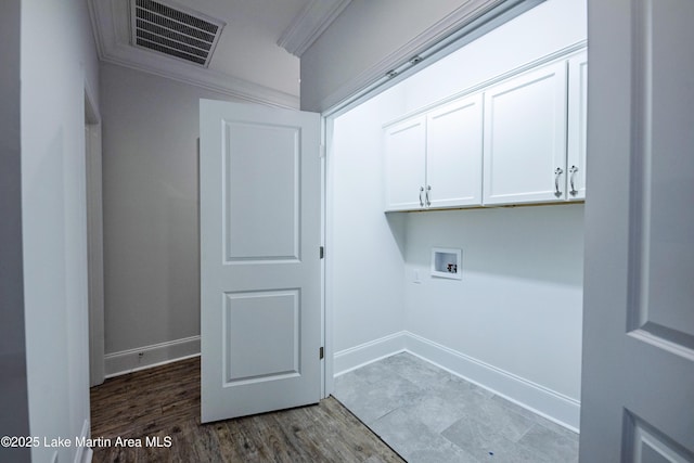 clothes washing area featuring cabinets, ornamental molding, dark hardwood / wood-style floors, and washer hookup