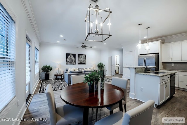 dining space featuring ceiling fan, ornamental molding, dark hardwood / wood-style flooring, and sink