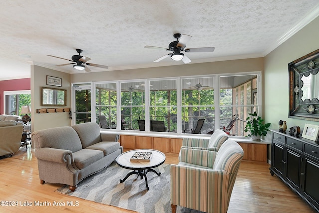 living room with a textured ceiling, ceiling fan, crown molding, and light hardwood / wood-style flooring