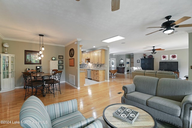 living room with a healthy amount of sunlight, light wood-type flooring, and crown molding