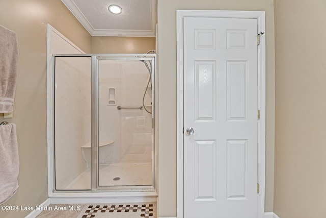 bathroom featuring an enclosed shower, a textured ceiling, and ornamental molding