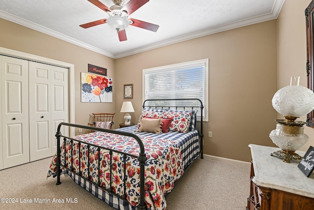 carpeted bedroom featuring a textured ceiling, ceiling fan, crown molding, and a closet