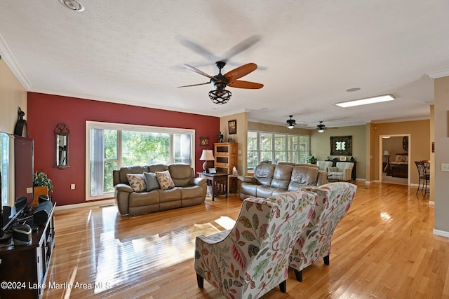 living room with ornamental molding, a textured ceiling, and light hardwood / wood-style flooring