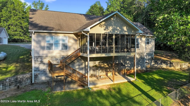 rear view of property featuring a sunroom, a yard, and a patio