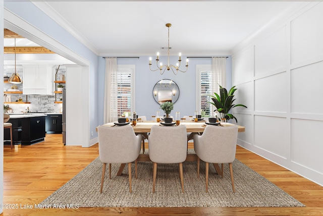 1412 Annalue Dr, Auburn, AL 36830 - dining space featuring a chandelier, light wood-type flooring, crown molding, and baseboards