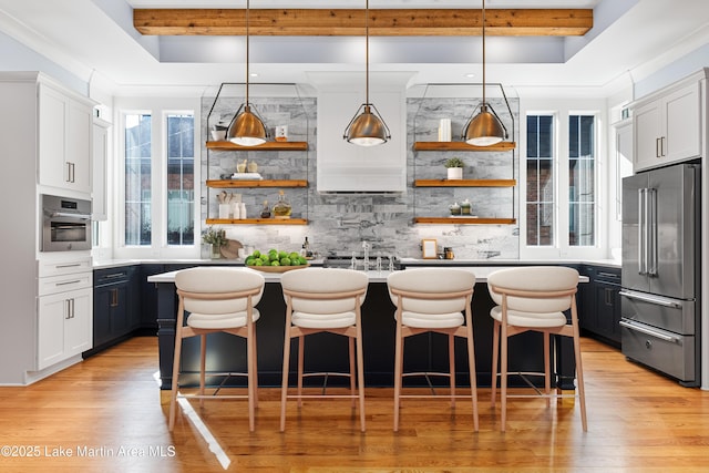 1412 Annalue Dr, Auburn, AL 36830 - kitchen featuring appliances with stainless steel finishes, open shelves, a center island with sink, tasteful backsplash, and light wood-style floors