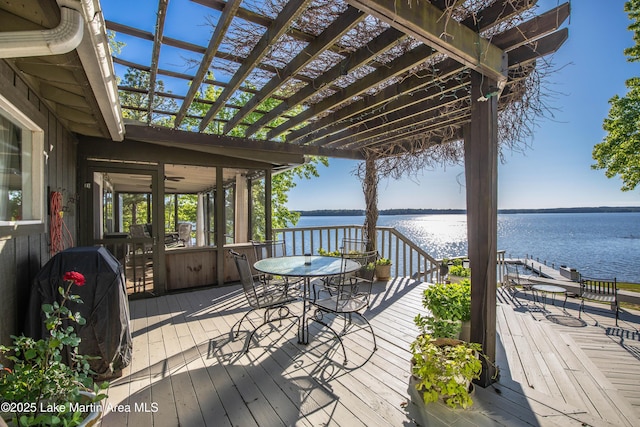 wooden deck with a water view, outdoor dining area, a grill, and a pergola