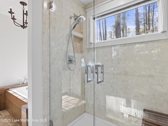 bathroom featuring a chandelier and a shower stall