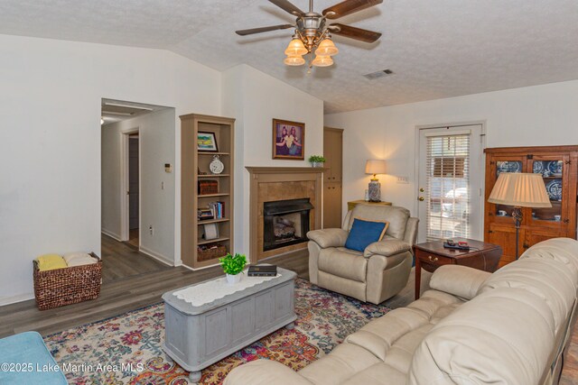 100 Royal Dr, Equality, AL 36026 - living area featuring visible vents, a ceiling fan, a tiled fireplace, wood finished floors, and lofted ceiling