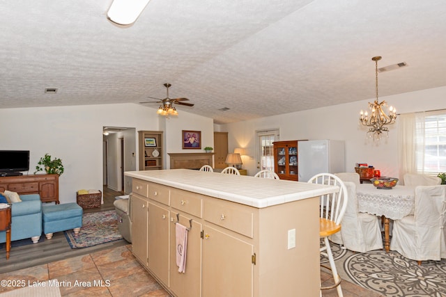 100 Royal Dr, Equality, AL 36026 - kitchen with visible vents, open floor plan, tile countertops, lofted ceiling, and freestanding refrigerator