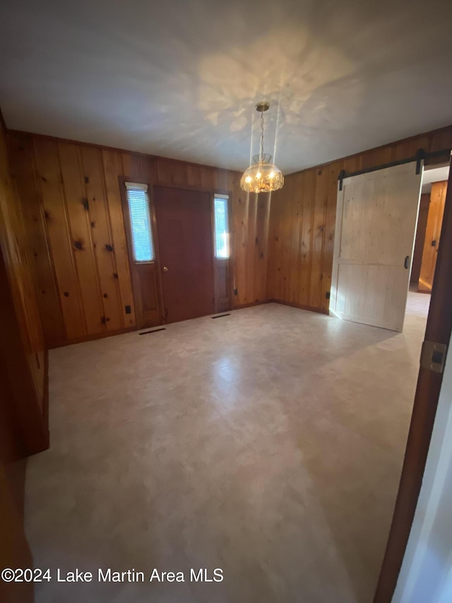 empty room with a barn door and wooden walls