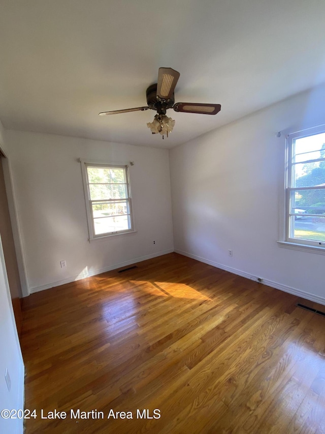 empty room with ceiling fan and hardwood / wood-style floors