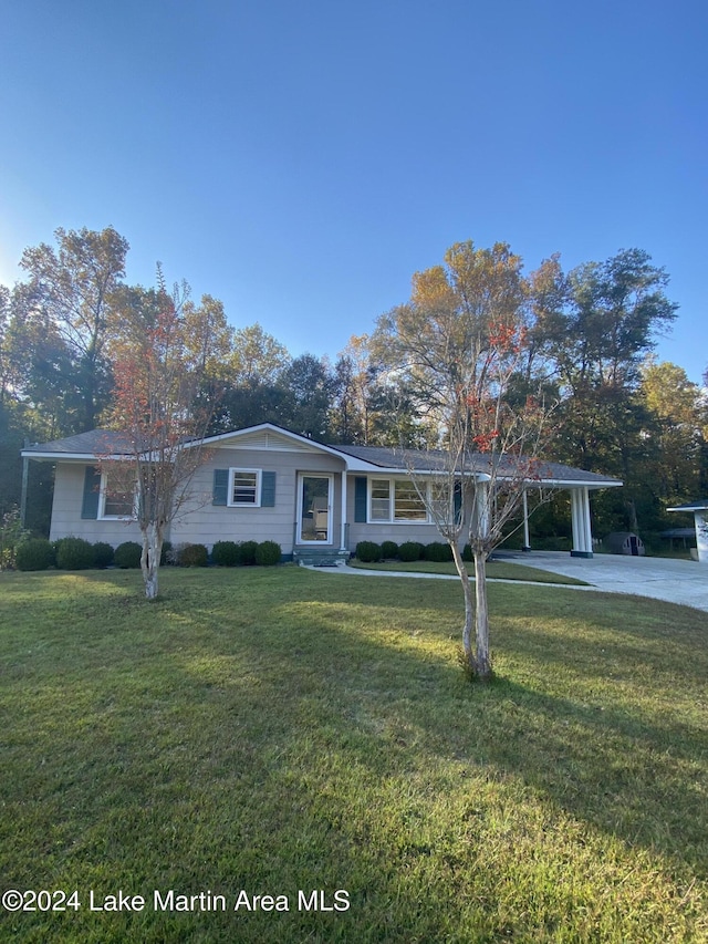 ranch-style home featuring a carport and a front lawn