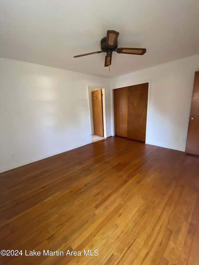 unfurnished bedroom with hardwood / wood-style floors, a closet, and ceiling fan