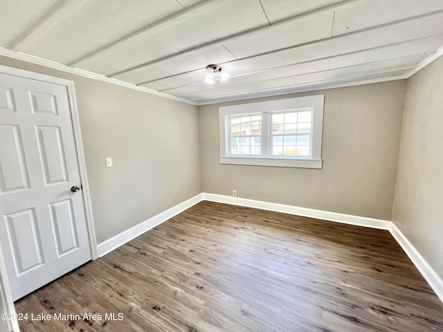 spare room with hardwood / wood-style floors and crown molding