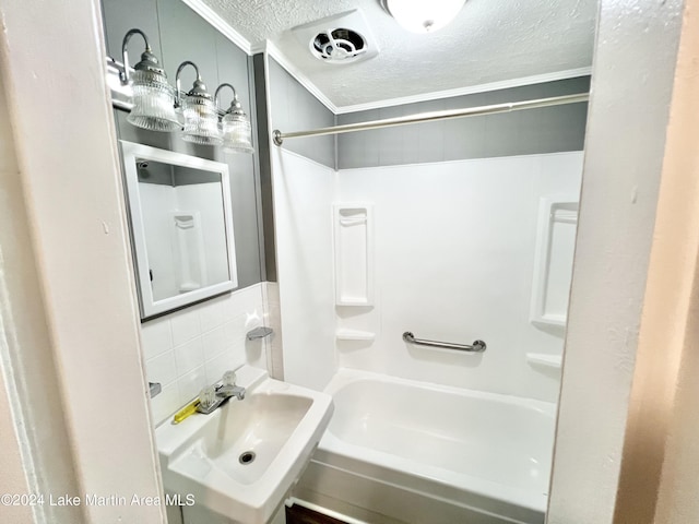 bathroom featuring tasteful backsplash, sink, shower / bathtub combination, and a textured ceiling