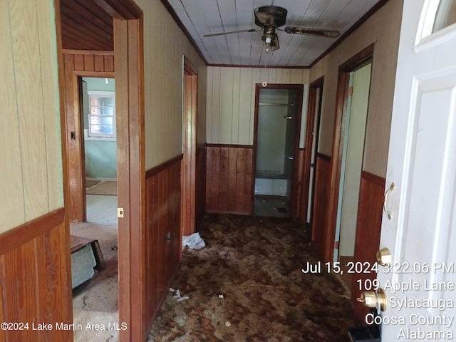 hallway featuring wood walls