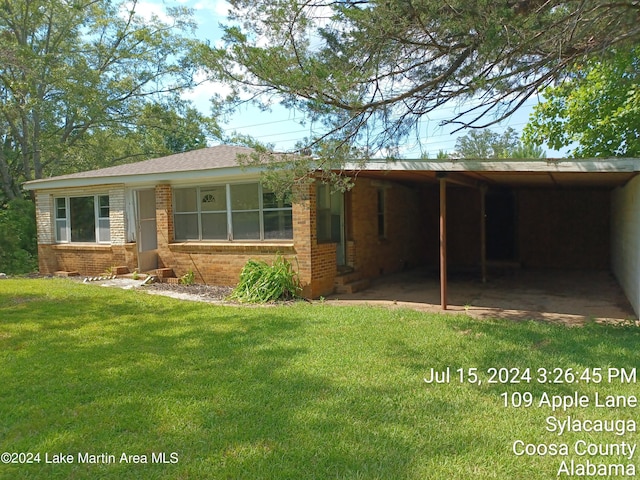 view of front of house with a carport and a front lawn