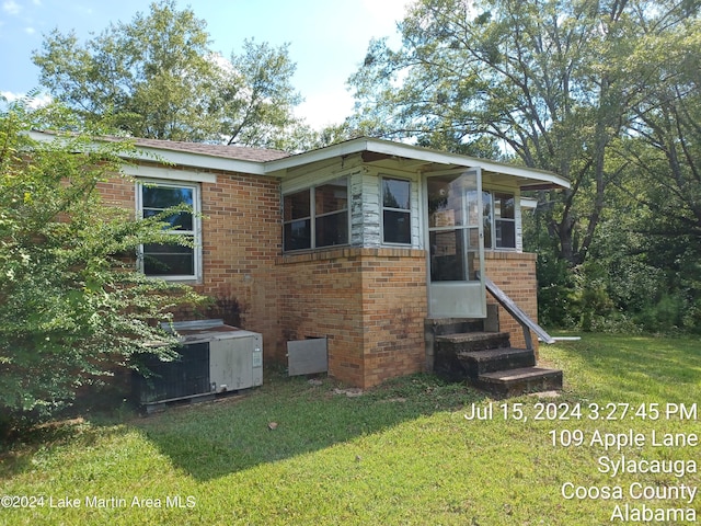 view of front of house with a front yard and central AC