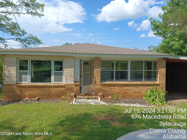 view of front facade with a carport and a front yard