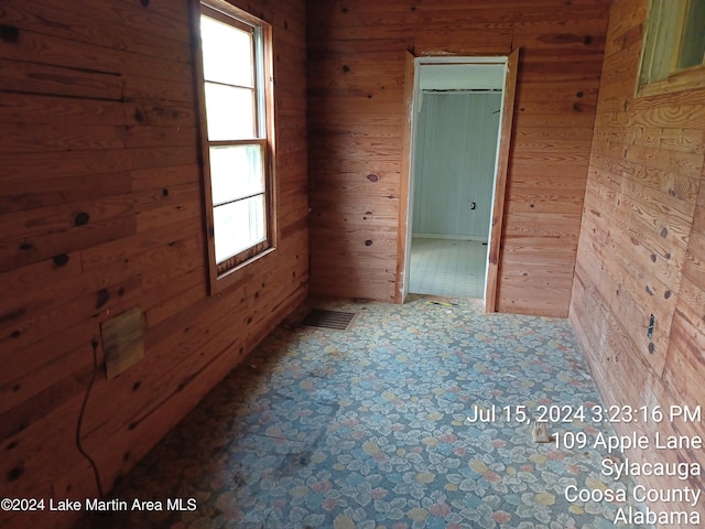 empty room with a wealth of natural light and wooden walls