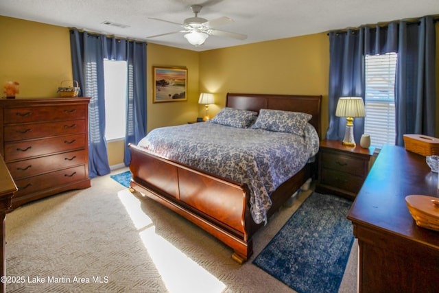 carpeted bedroom featuring a textured ceiling and ceiling fan