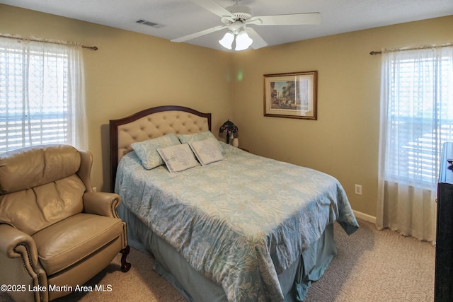 carpeted bedroom featuring ceiling fan and multiple windows