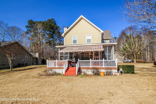 view of front property featuring a front lawn, a sunroom, and a deck