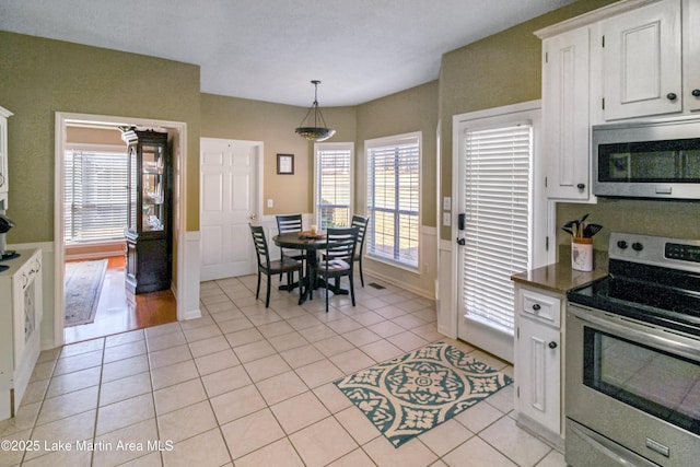 kitchen with white cabinetry, light tile patterned floors, and stainless steel appliances