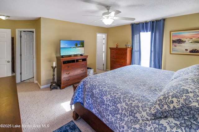 carpeted bedroom featuring ceiling fan and a textured ceiling