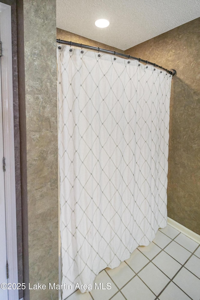 bathroom with a textured ceiling and tile patterned flooring