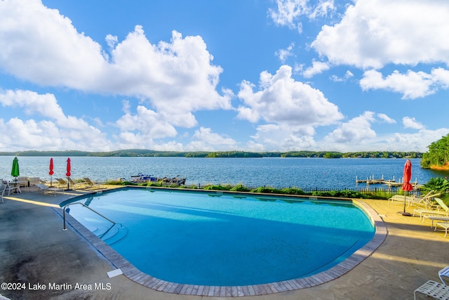 view of swimming pool with a water view and a patio