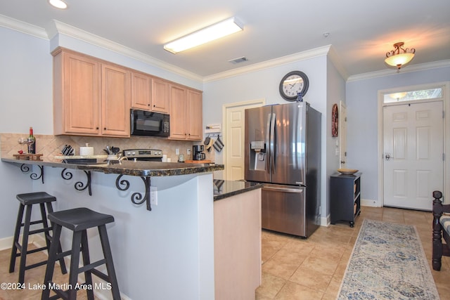 kitchen featuring kitchen peninsula, crown molding, dark stone countertops, decorative backsplash, and appliances with stainless steel finishes