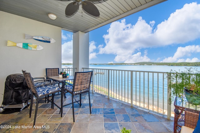 balcony with ceiling fan, a water view, and a beach view