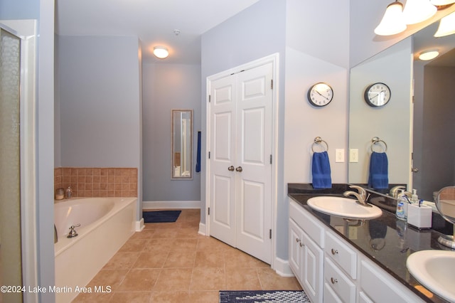 bathroom featuring a bathing tub, vanity, and tile patterned flooring