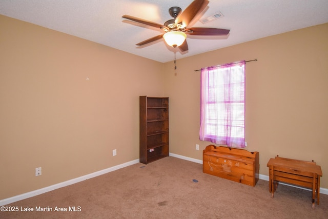 interior space with visible vents, a ceiling fan, baseboards, and carpet floors