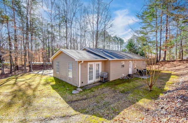 view of side of home featuring a yard and a shingled roof