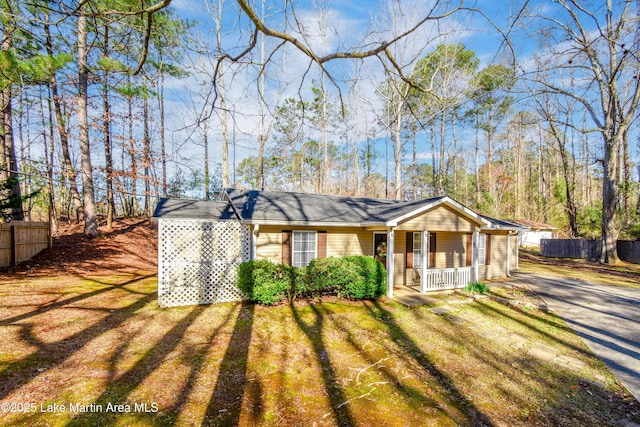 view of front of house with a porch, a front lawn, and fence