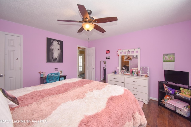 bedroom featuring a ceiling fan, dark wood-style floors, and a textured ceiling