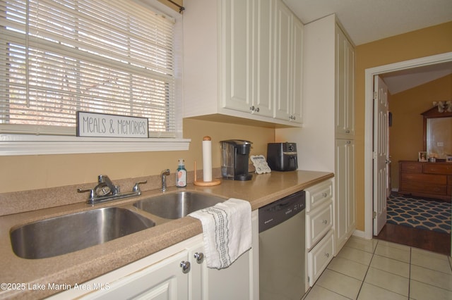 kitchen with light tile patterned floors, white cabinetry, a sink, light countertops, and dishwasher