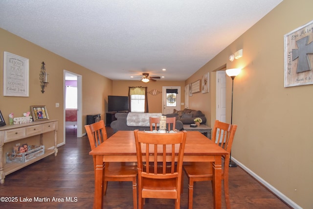 dining room with baseboards, a textured ceiling, dark wood-style floors, and a ceiling fan